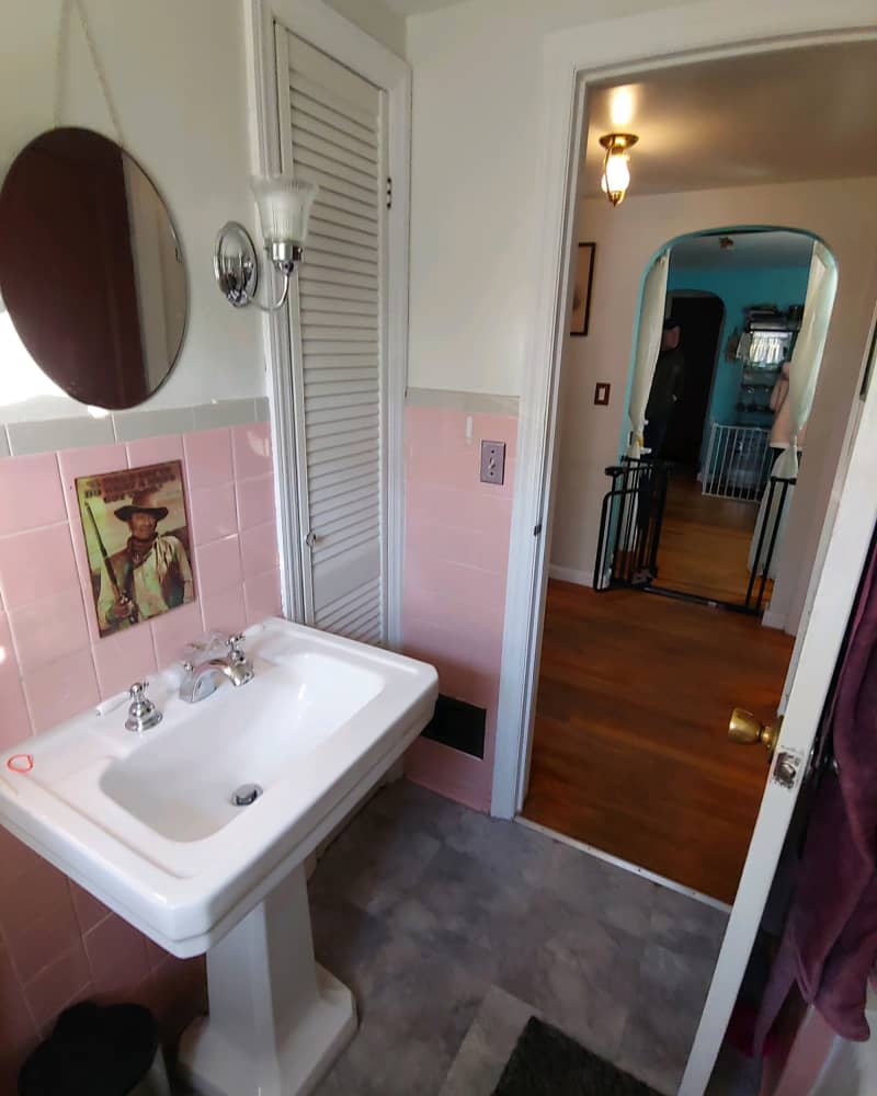 white bathroom with pink tile and gray floor before remodel