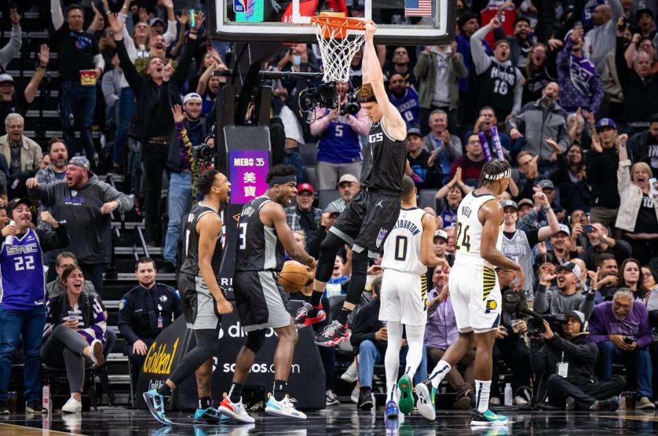 Sacramento Kings guard/forward Kevin Huerter (9) dunks the ball on a Kings run in the third quarter against the Indiana Pacers at the NBA basketball game Wednesday, Nov. 30, 2022, at Golden 1 Center in Sacramento. Teammates, from left, guards Malik Monk (0) and Terence Davis II (3) celebrate, while former Kings and now Pacers guards Tyrese Haliburton (0) and Buddy Hield walk away.