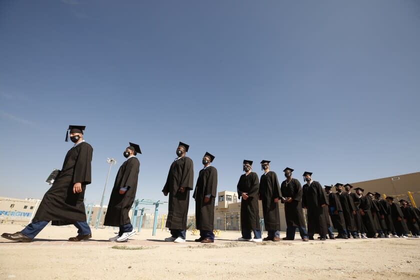 LANCASTER, CA - OCTOBER 05: Graduates of Cal State LA's Prison B.A. Program during the begin the procession in the prison yard for their graduation ceremony inside the California State Prison in Lancaster. A ceremony followed the graduation events for classmates whose sentences were commuted. The program is the first of its kind in California. California State Prison on Tuesday, Oct. 5, 2021 in Lancaster, CA. (Al Seib / Los Angeles Times).