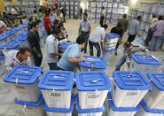 Workers adjust boxes of parliamentary election ballots at a tally centre in Baghdad March 9, 2010. Iraq held their parliamentary election on Sunday. REUTERS/Thaier al-Sudani