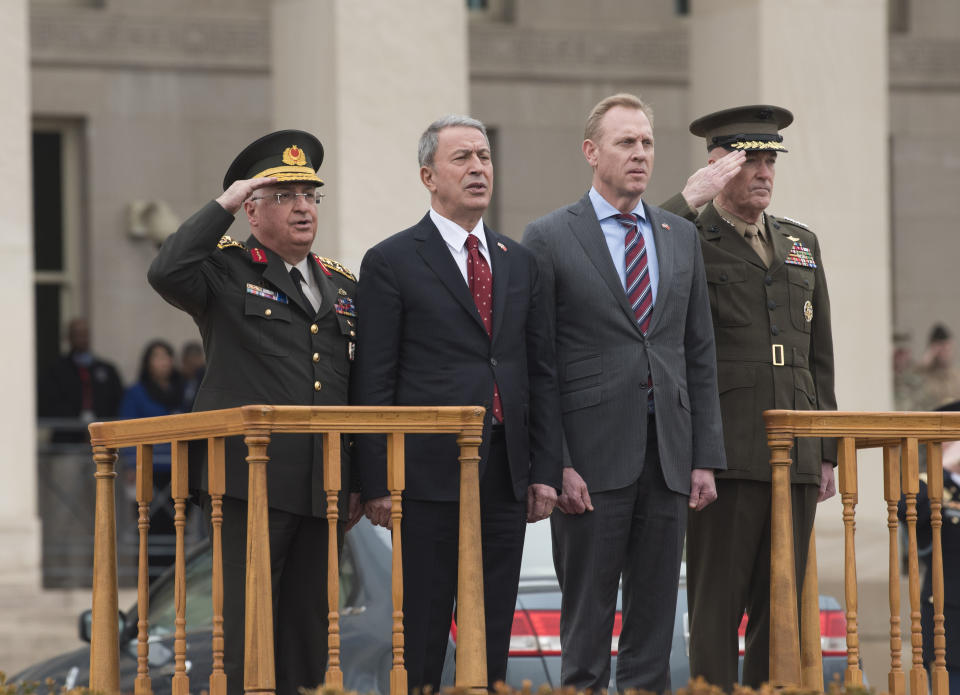 Acting Secretary of Defense Patrick Shanahan, center right, and Chairman of the Joint Chiefs Gen. Joseph Dunford, right, host an arrival ceremony for Turkish Defense Minister Hulusi Akar and Gen. Yasar Guler, left, on Friday, Feb. 22, 2019 at the Pentagon in Washington. (AP Photo/Kevin Wolf)