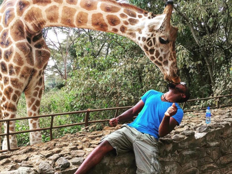 Lawrence Phillips kissing a giraffe in Kenya, 2015