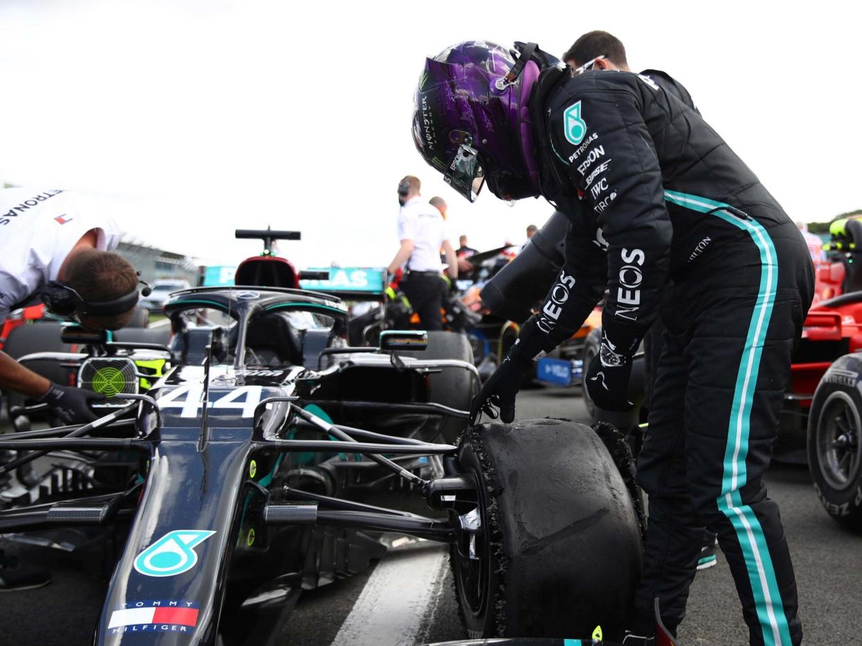 Lewis Hamilton inspects his damaged Mercedes after winning the British Grand Prix: AP