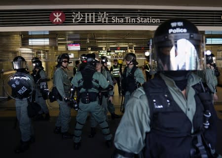 Police officers stand outside closed Sha Tin subway station during a rally by anti-government protesters in Sha Tin