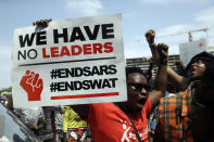 FILE - In this Oct. 15, 2020, file photo, people hold banners as they protest against police brutality at Lekki Toll Plaza in Lagos, Nigeria. The protests started in Lagos against a police unit known as the Special Anti-Robbery Squad, or SARS, which faced widespread accusations of brutality, unwarranted arrests and bribery. It climaxed on Oct. 20, 2020, when protesters were killed nationwide, according to Amnesty International's Nigerian office. (AP Photo/Sunday Alamba, File)