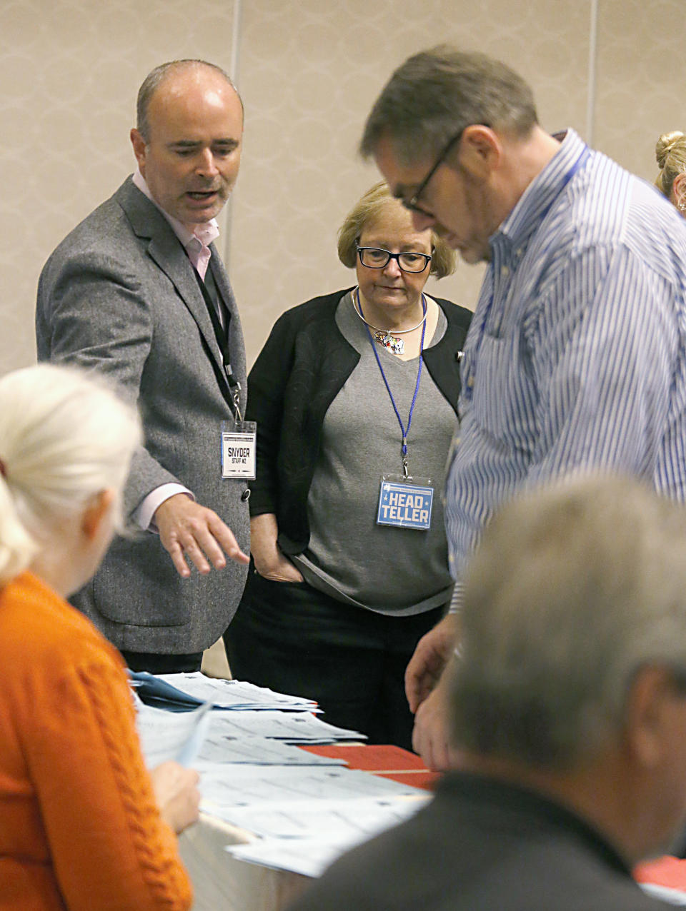 Chris Ashby, left, an observer from the Pete Snyder campaign, asks a question of Jeff Ryer, Press Secretary for the Senate Republican Caucus, right, as Head Teller Kay Crews, center, a Certified Parlimentarian, looks on during the counting of ballots for Virginia's Republican gubernatorial nominee race inside a ballroom at the Marriott Hotel in Richmond, Va., Monday, May 10, 2021. (Bob Brown/Richmond Times-Dispatch via AP)