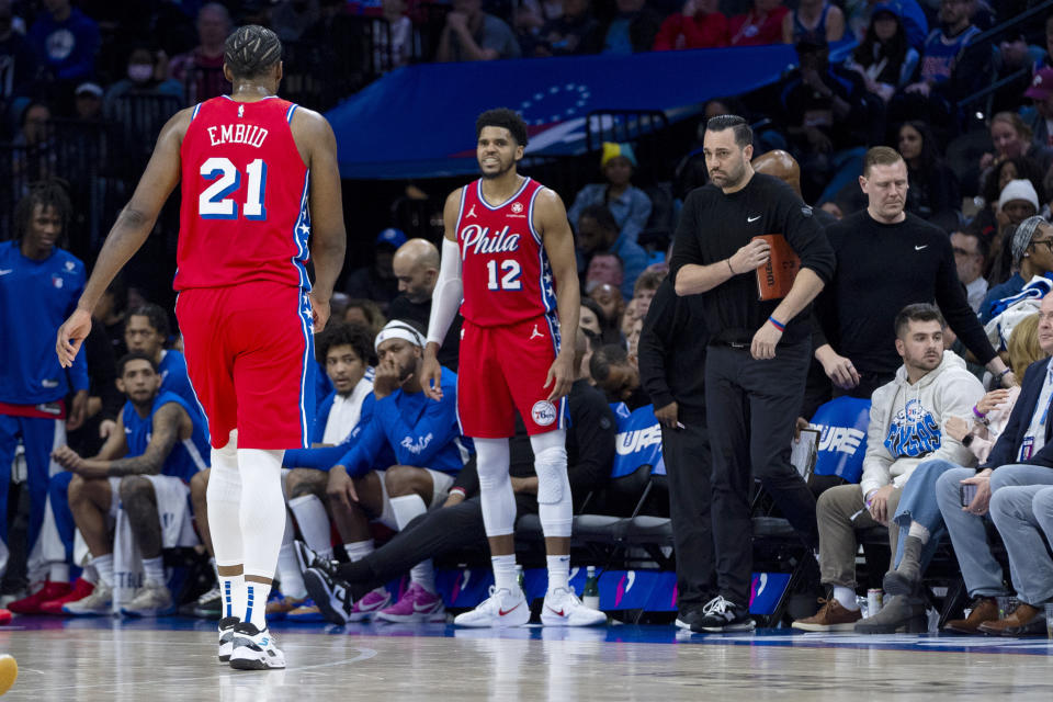 Philadelphia 76ers' Joel Embiid, left, heads off the court and straight to the locker room after grabbing his left knee on the previous possession during the first half of an NBA basketball game against the Orlando Magic, Friday, April 12, 2024, in Philadelphia. (AP Photo/Chris Szagola)