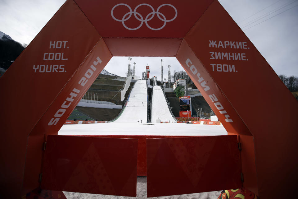 Volunteers work on the course after the ski jumping Nordic combined team Gundersen large hill competition training was cancelled due to the condition of the landing area following Tuesday's steady, daylong rain, at the 2014 Winter Olympics, Wednesday, Feb. 19, 2014, in Krasnaya Polyana, Russia. (AP Photo/Gregorio Borgia)