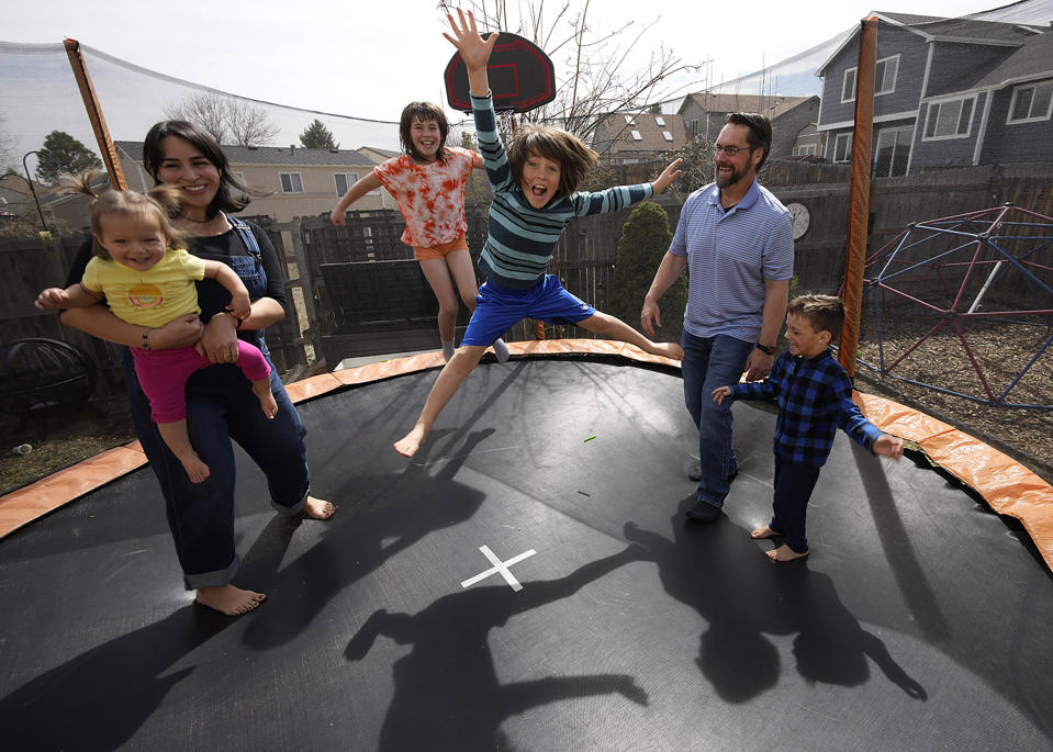 Christina and Roy Taylor pose with their children Magdalena, River, Titus and Ofelia in the family's backyard in Littleton, Colo., on Sunday, March 27, 2022. Taylor chose to get an abortion when she found out after 20 weeks that her baby had no kidneys or bladder. Taylor said she honors her loss with the casts, which were made by the hospital's bereavement team. (AP Photo/David Zalubowski)