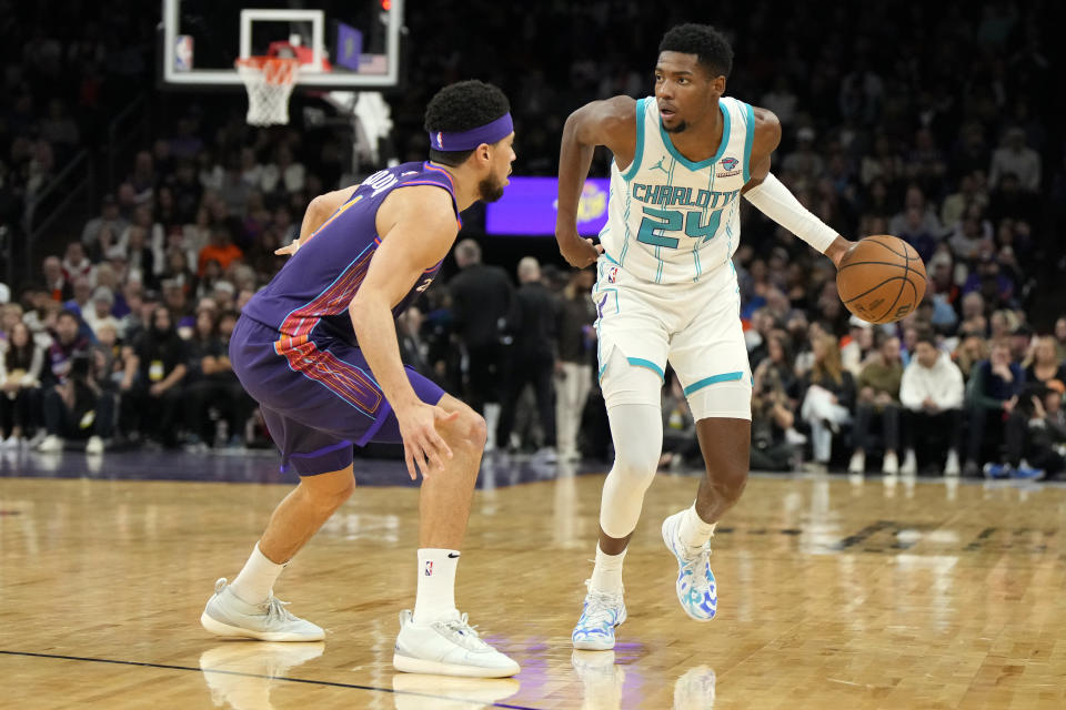 Charlotte Hornets forward Brandon Miller (24) drives on Phoenix Suns guard Devin Booker during the first half of an NBA basketball game, Friday, Dec. 29 2023, in Phoenix. (AP Photo/Rick Scuteri)