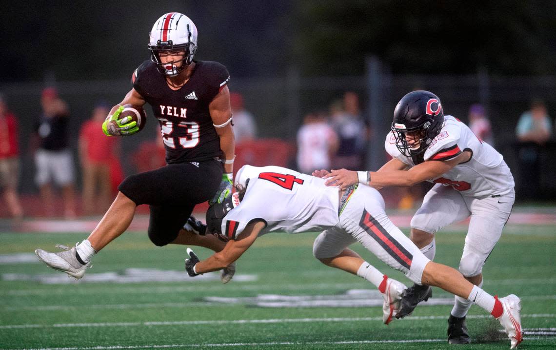 Yelm running back Brayden Platt leaps to elude Camas defensive back Jared Williams (4) and linebacker Nikko Speer during Friday night’s season-opening football game at Yelm High School in Yelm, Washington on Friday, Sept. 2, 2022.