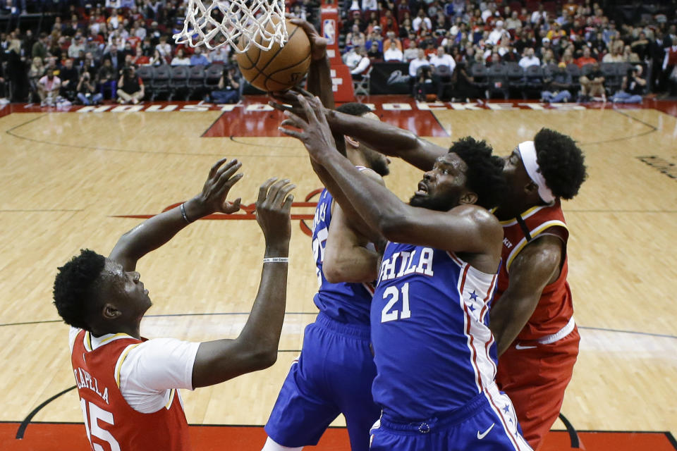 Philadelphia 76ers center Joel Embiid (21) and Houston Rockets forward Danuel House Jr., right, vie for a rebound during the first half of an NBA basketball game Friday, Jan. 3, 2020, in Houston. (AP Photo/Eric Christian Smith)
