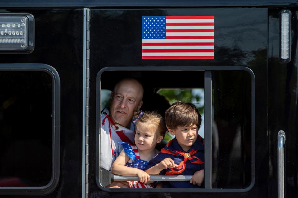 People look out from a Dearborn firetruck during the 96th Memorial Day Parade along Michigan Avenue in Dearborn on Monday, May 30, 2022. The parade returns after a two-year hiatus due to the pandemic.