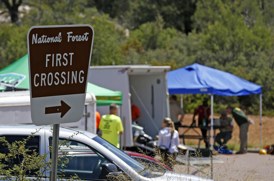 <p>First responders gather near the entrance to the First Crossing recreation area during the search and rescue operation for a victim in a flash flood along the banks of the East Verde River Monday, July 17, 2017, in Payson, Ariz. The bodies of nearly a dozen children and adults have been found after Saturday’s flash flooding poured over a popular swimming area in the Tonto National Forest. (AP Photo/Ross D. Franklin) </p>