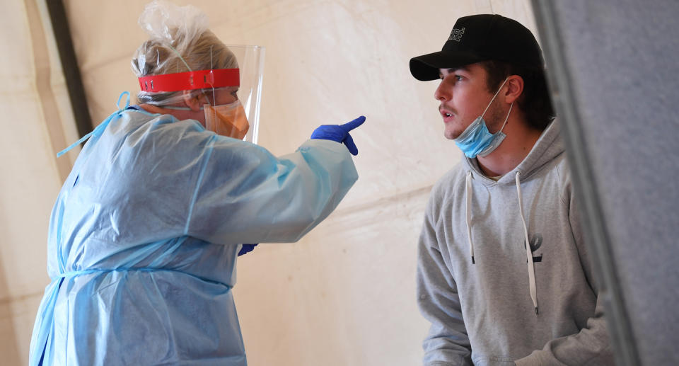 A healthcare worker conducts a test on a patient at a pop-up Covid19 testing centre at the Kilmore Memorial Hall in Kilmore, Victoria. Source: AAP