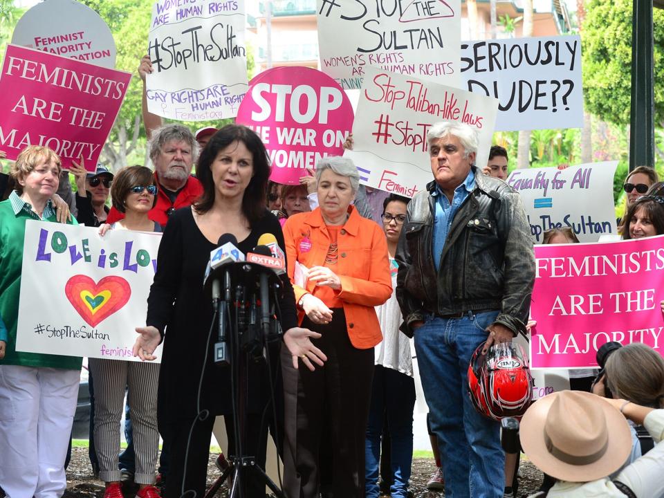 Jay Leno watches as his wife Mavis speaks as supporters of women's rights and LGBT groups protest across from the Beverly Hills Hotel