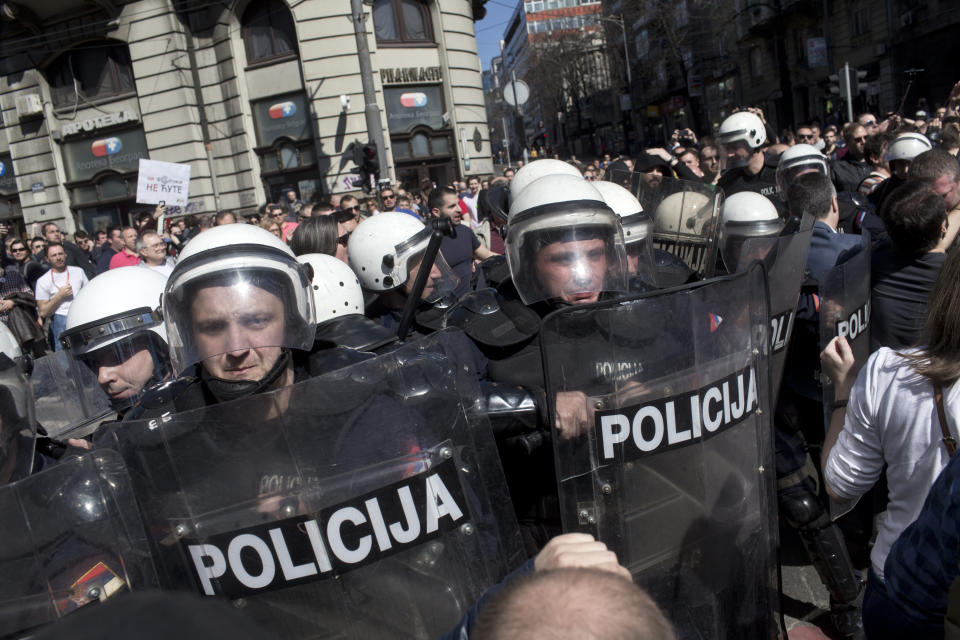 Riot police officers push protesters in Belgrade, Serbia, Sunday, March 17, 2019. As Serbian president Aleksandar Vucic held a news conference in the presidency building in downtown Belgrade, thousands of opposition supporters gathered in front demanding his resignation. Skirmishes with riot police were reported, including officers firing tear gas against the protesters who have pledged to form a human chain around the presidency to prevent Vucic from leaving the building. (AP Photo/Marko Drobnjakovic)