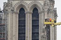 Una grúa levanta a expertos mientras inspeccionan la dañada catedral Notre Dame tras el incendio en París, el martes 16 de abril de 2019. (AP Foto/Christophe Ena)