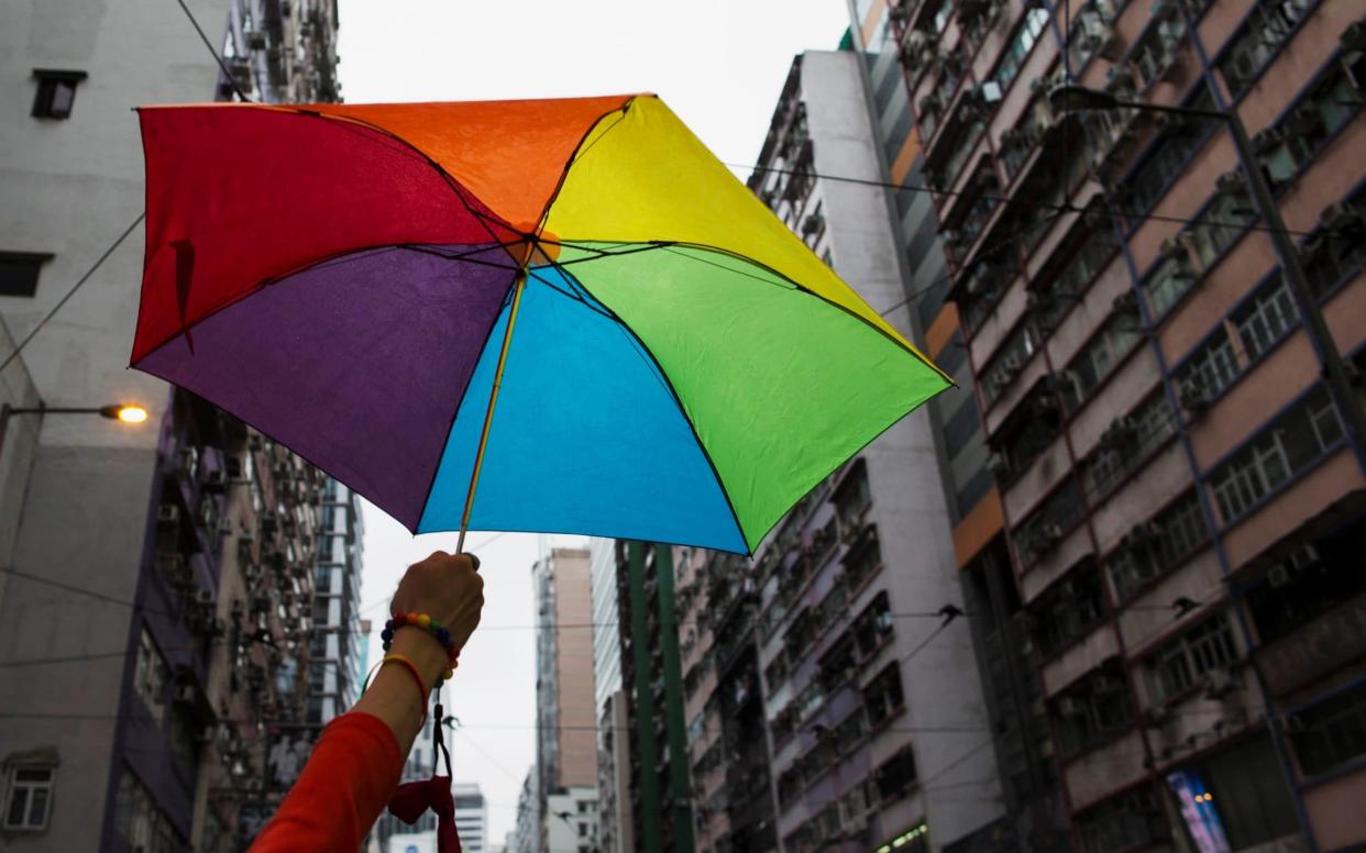 A participant holds a rainbow umbrella as he attends a lesbian, gay, bisexual and transgender (LGBT) Pride Parade in Hong Kong - REUTERS