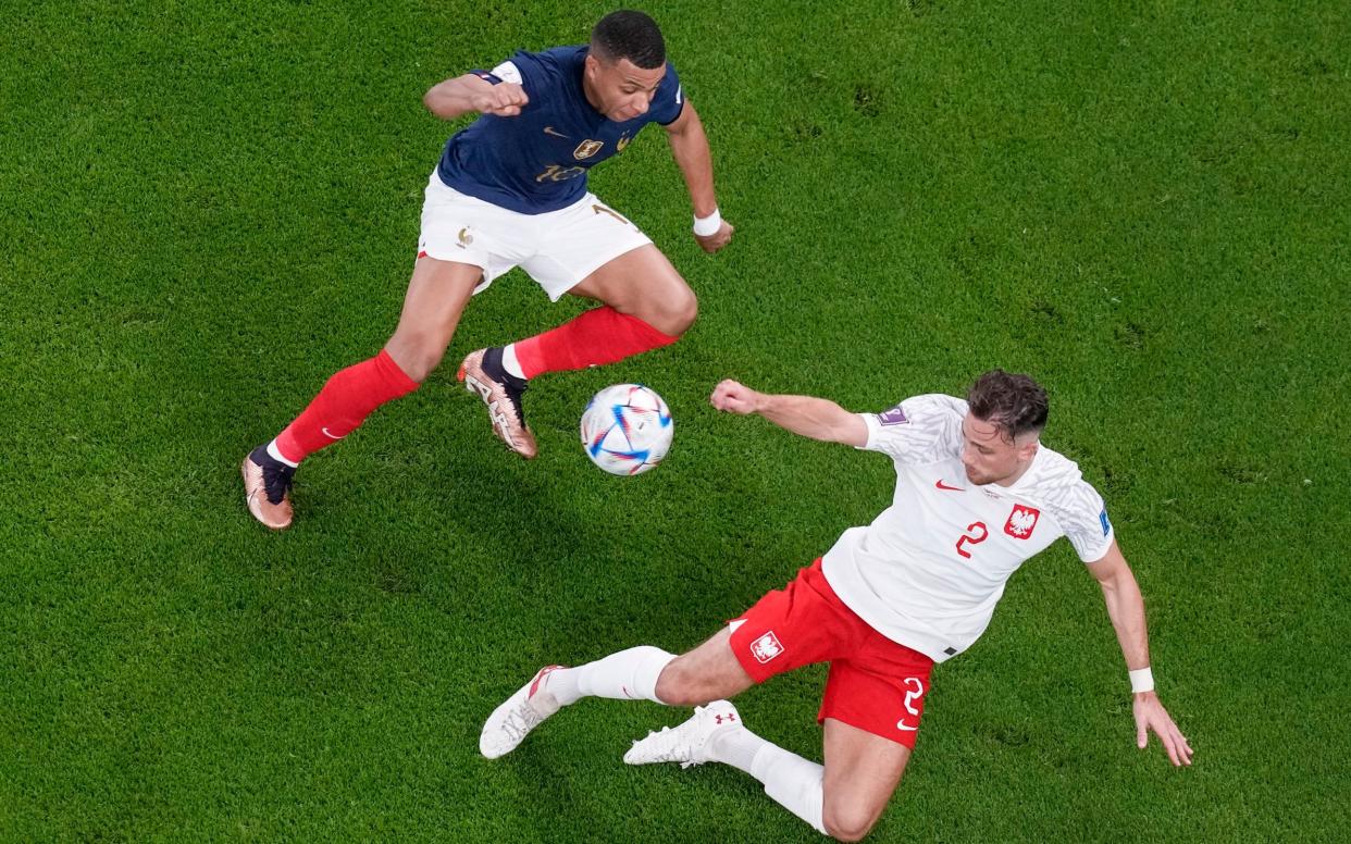 France's Kylian Mbappe, left, fights for the ball with Poland's Matty Cash during the World Cup round of 16 match between France and Poland - AP Photo/Thanassis Stavrakis