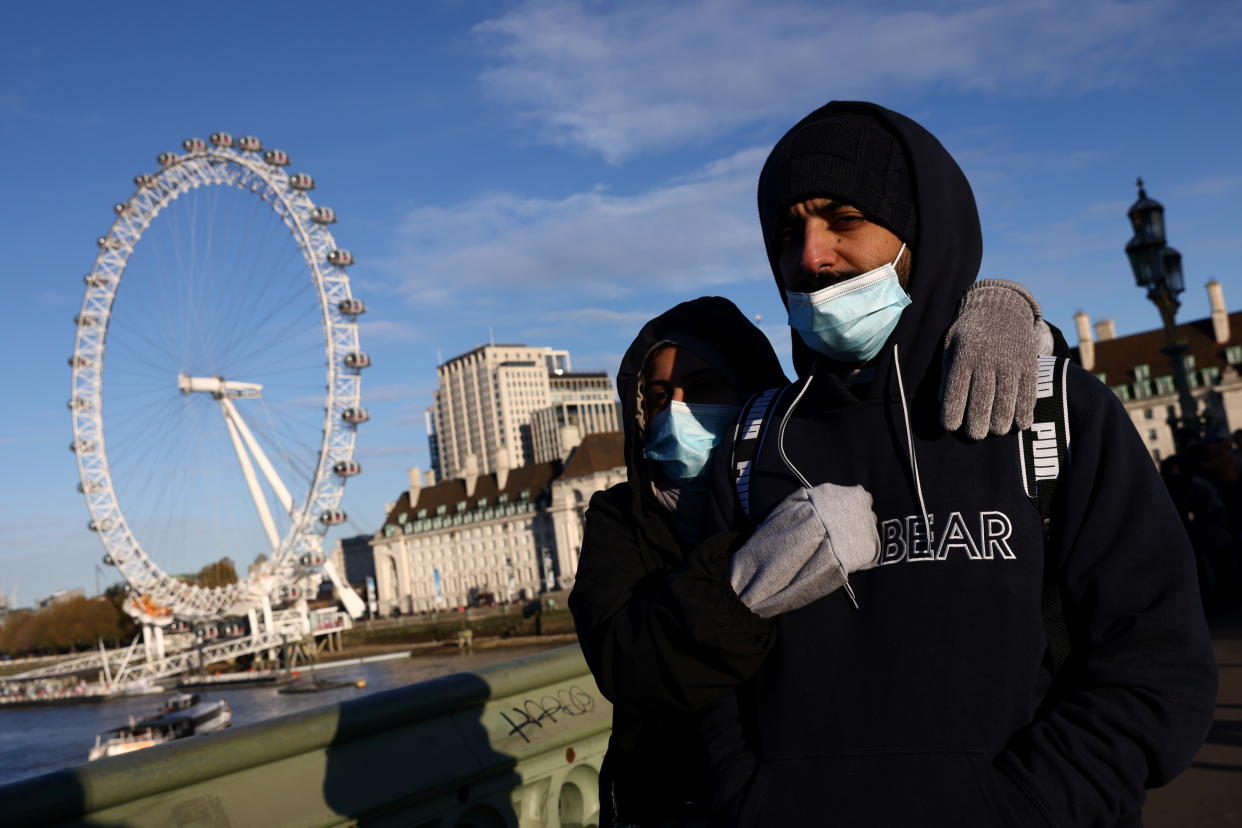 People wearing face masks walk over Westminster Bridge after new measures were announced yesterday due to Omicron coronavirus variant, in London, Britain, November 28, 2021. REUTERS/Tom Nicholson