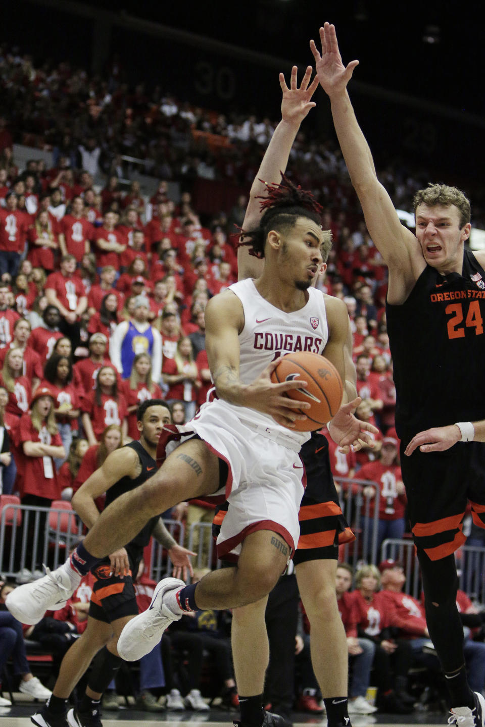 Washington State guard Isaac Bonton, left, passes the ball around Oregon State Oregon State guard Zach Reichle, back, and forward Kylor Kelley during the second half of an NCAA college basketball game in Pullman, Wash., Saturday, Jan. 18, 2020. Washington State won 89-76. (AP Photo/Young Kwak)