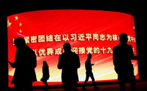 A sign advertising China's 19th National Congress with the words 'Unite closely with comrade Xi Jinping' outside a shopping complex in Beijing - Credit: EPA