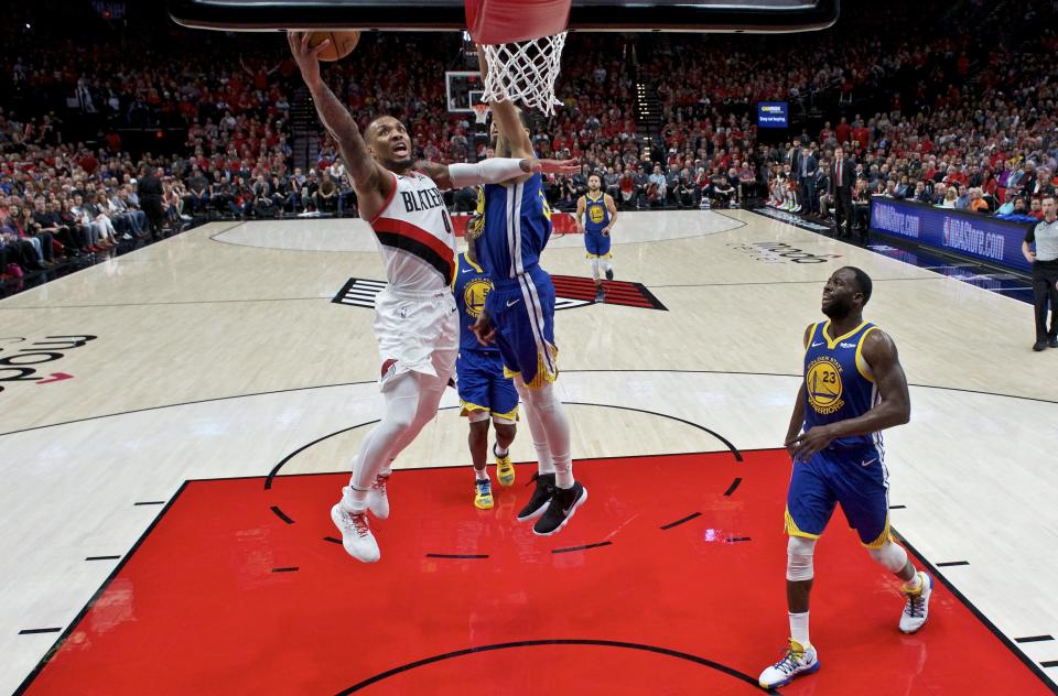 Portland Trail Blazers guard Damian Lillard, left, shoots over Golden State Warriors guard Shaun Livingston during the second half of Game 4 of the NBA basketball playoffs Western Conference finals Monday, May 20, 2019, in Portland, Ore. The Warriors won 119-117 in overtime. (AP Photo/Craig Mitchelldyer)