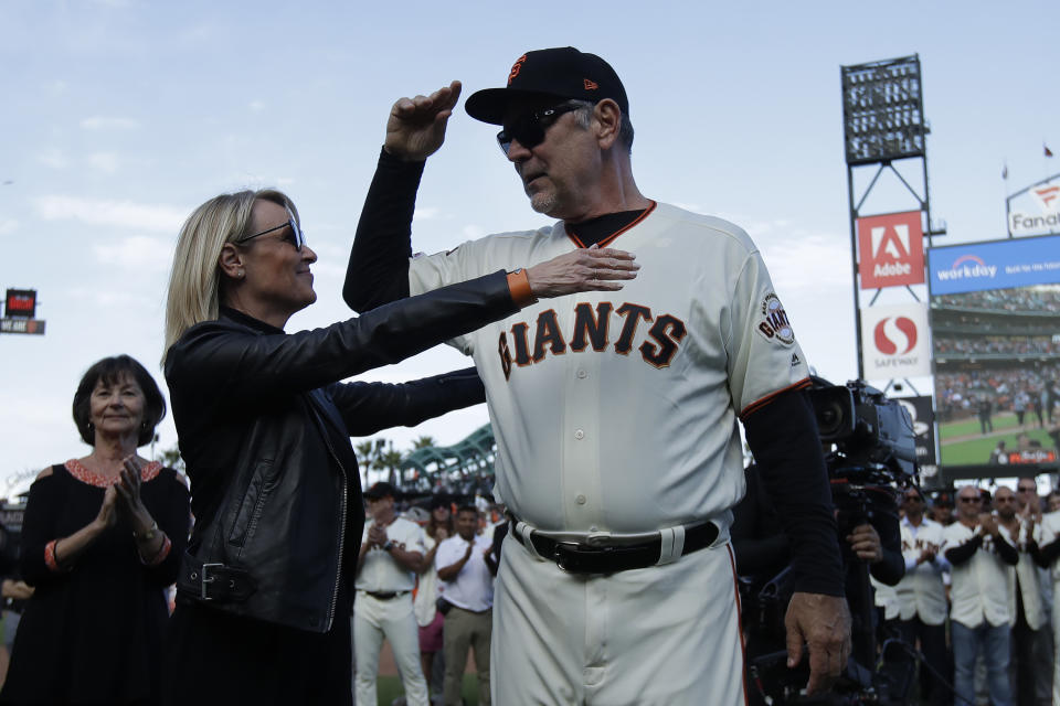 San Francisco Giants manager Bruce Bochy, right, hugs his wife Kim during a ceremony honoring Bochy after a baseball game between the Giants and the Los Angeles Dodgers in San Francisco, Sunday, Sept. 29, 2019. (AP Photo/Jeff Chiu, Pool)