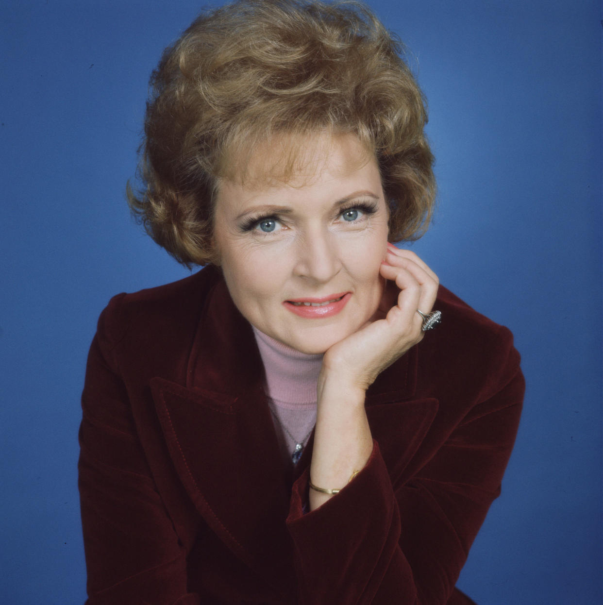 Publicity still of American actress Betty White, who plays Sue Ann Nivens on 'The Mary Tyler Moore Show' (also known as 'Mary Tyler Moore'), 1975. She wears a burgandy velvet jacket over a pink turtleneck sweater, and poses with her chin in the palm of her left hand. (Photo by CBS Photo Archive/Getty Images)