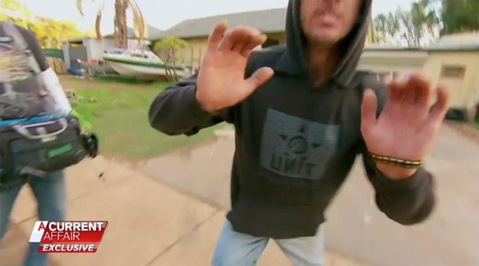 An Adelaide man pushes a cameraman to the ground, who was filming for a segment about the man's unpaid mortgage. Source: A Current Affair