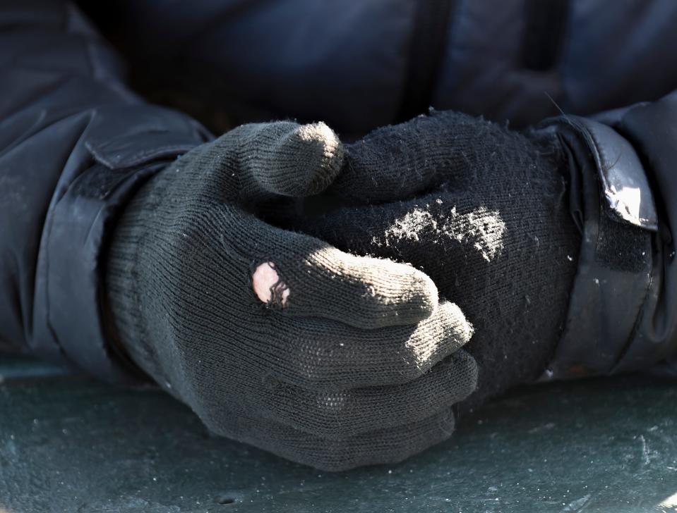 Wearing gloves, David Bruce, a Fort Pierce snowbird from of Muskegon, Michigan, keeps warm sitting at a picnic table socializing with friends by the south jetty on Monday, Jan. 24, 2022, in Fort Pierce. 