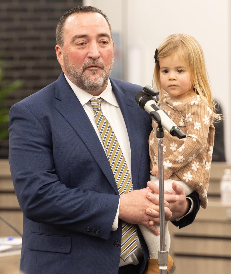 William Sherer II holds his granddaughter Ella Carnahan, 2, after Sherer was sworn in as Canton's new mayor.