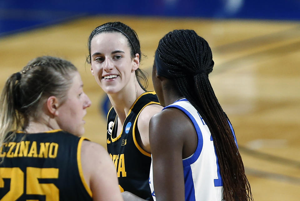 Iowa guard Caitlin Clark smiles at Kentucky guard Rhyne Howard.