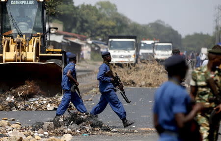 Policemen walk in front of bulldozers, which were sent to clear barricades, during a protest against President Pierre Nkurunziza's decision to run for a third term in Bujumbura, Burundi, May 29, 2015. REUTERS/Goran Tomasevic