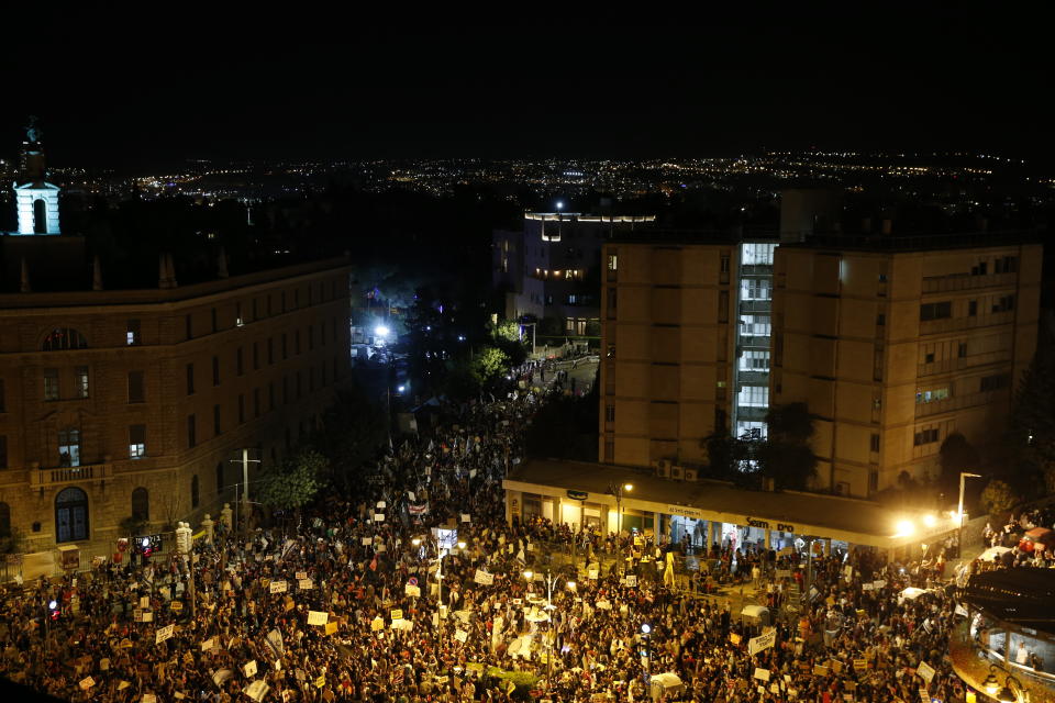 Thousands of demonstrators chant slogans and hold signs during a protest against Israel's Prime Minister Benjamin Netanyahu outside his residence in Jerusalem, Saturday, July 25, 2020. Protesters demanded that the embattled leader resign as he faces a trial on corruption charges and grapples with a deepening coronavirus crisis. (AP Photo/Ariel Schalit)