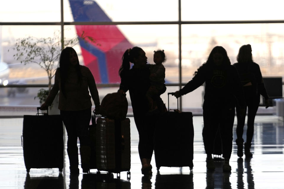 People pass through Salt Lake City International Airport, Wednesday, Jan. 11, 2023, in Salt Lake City. The world's largest aircraft fleet was grounded for hours by a cascading outage in a government system that delayed or canceled thousands of flights across the U.S. (AP Photo/Rick Bowmer)