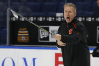 Calgary Flames associate coach Geoff Ward gives instruction during an NHL hockey practice Tuesday, Nov. 26, 2019, in Buffalo, N.Y. Flames general manager Brad Treliving says coach Bill Peters remains on the staff but wasn’t certain whether he’d be behind the bench for the next game. The team and the NHL are both investigating an allegation the Peters directed racial slurs at a player 10 years ago when the two were in the minors. Akim Aliu, a Nigerian-born player, says Peters “dropped the N bomb several times” in a dressing room during his rookie year. (AP Photo/Jeffrey T. Barnes)