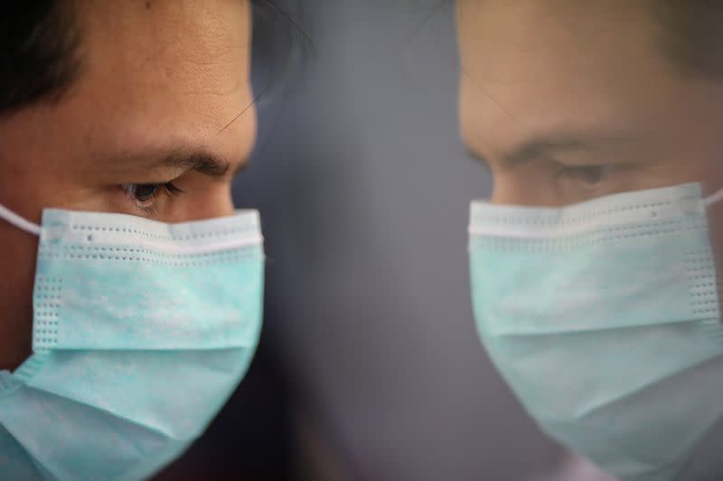 Scientist is reflected as he works on cells that produce antibodies against the coronavirus disease (COVID-19), in a university lab in Athens