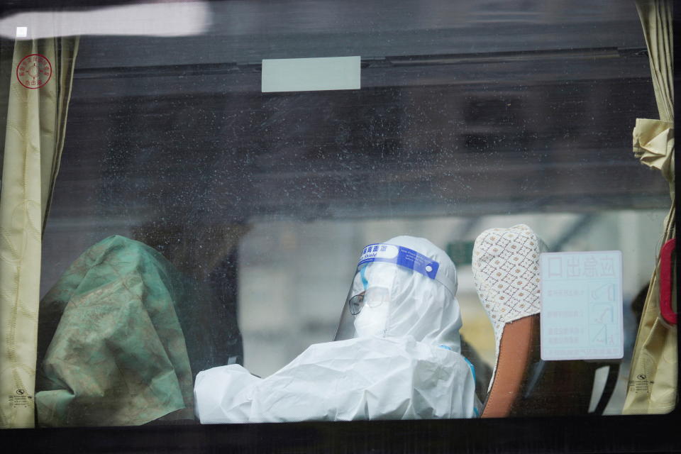 A woman in a protective suit sits inside a bus on a street during lockdown, amid the coronavirus disease (COVID-19) pandemic, in Shanghai, China, May 1, 2022. REUTERS/Aly Song