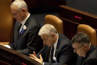 CORRECTS TO SWEARING-IN OF PARLIAMENT, NOT GOVERNMENT - Israel's outgoing Prime Minister Yair Lapid, center, attends the swearing-in ceremony for Israel's parliament, at the Knesset, in Jerusalem, Tuesday, Nov. 15, 2022. (AP Photo/ Maya Alleruzzo, Pool)