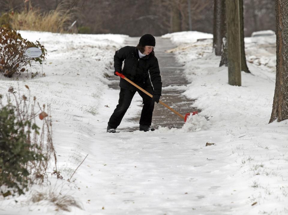 A woman shovels snow in Minneapolis, November 10, 2014. An arctic blast began to dump heavy snow in parts of the northern Rockies, Plains and the Great Lakes regions on Monday and meteorologists said temperatures are expected to plummet throughout the United States. (REUTERS/Eric Miller)