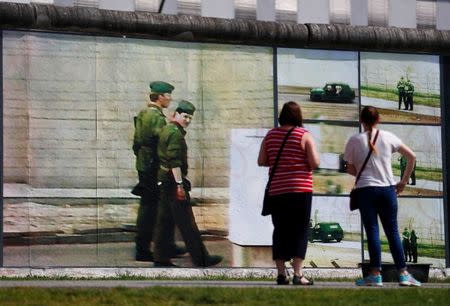 Visitors look at the art installation "Beyond The Wall" by German artist Stefan Roloff at the backside of the East Side Gallery in Berlin, Germany, August 10, 2017. REUTERS/Hannibal Hanschke