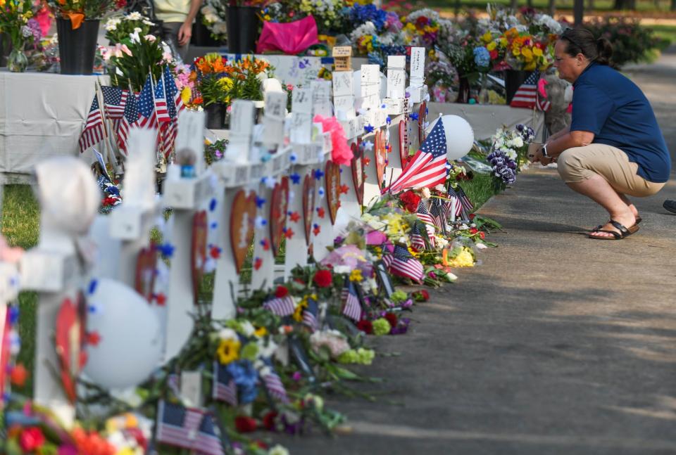 People stop by the memorial to pay their respects on Monday, June 3, 2019, for the victims of a mass shooting that killed twelve in Virginia Beach, Va. (Via OlyDrop)