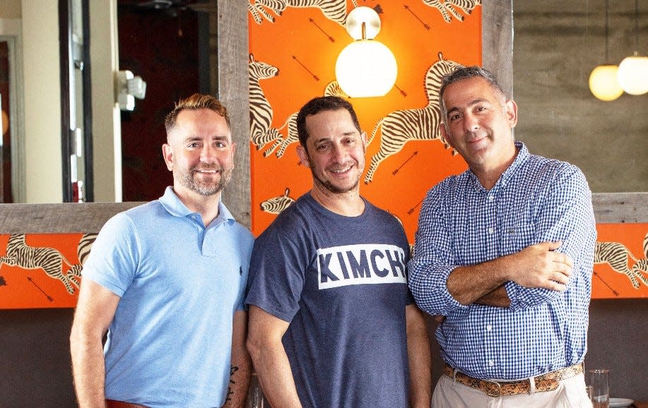 Meet the Almond bistro team: co-owner/founder Eric Lemonides (right) and his partner/fiancé Lee Felty (left) join co-founder and chef Jason Weiner (center) at the restaurant's Palm Beach location.