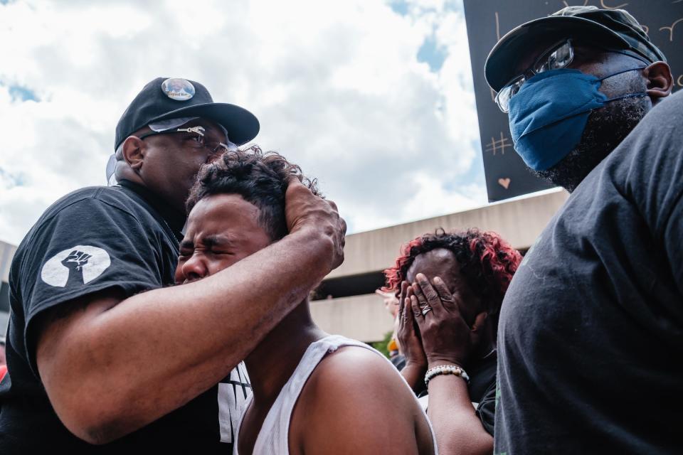 Javon Williams, 13, is comforted by the Rev. Jaland Finney, left, as he speaks during a rally for Jayland Walker on Sunday in Akron. Lynnette Williams reacts after Javon's impassioned speech. Javon had just viewed the video released by police on the Walker's shooting death.