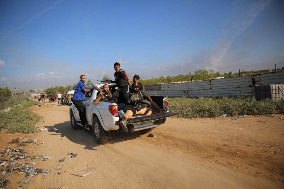 Hamas militants drive back to the Gaza Strip with the body of Shani Louk.