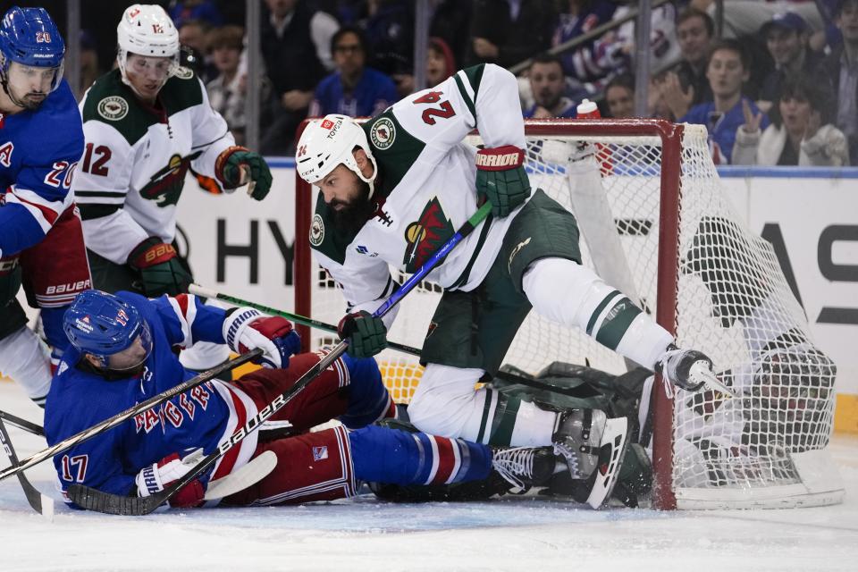 Minnesota Wild's Kaapo Kakko (24) protects his net from New York Rangers' Blake Wheeler (17) during the third period of an NHL hockey game Thursday, Nov. 9, 2023, in New York. (AP Photo/Frank Franklin II)