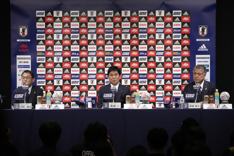 Japan national team head coach Hajime Moriyasu, center, with Japan Football Association (JFA) President Kozo Tajima, right, and Japan national team technical director Yasuharu Sorimachi announces the national team members for FIFA World Cup 2022 Tuesday, Nov. 1, 2022, in Tokyo. (AP Photo/Eugene Hoshiko)