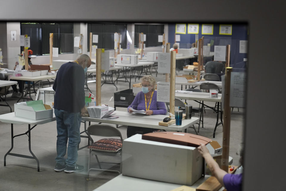 County employees process mail-in ballots at a Clark County election department facility Saturday, Oct. 31, 2020, in Las Vegas. (AP Photo/John Locher)